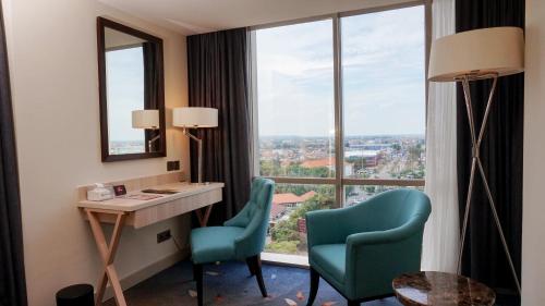 a room with a desk and two chairs and a window at Louis Kienne Hotel Pandanaran in Semarang