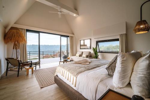 a bedroom with a large bed and a large window at Buyan Lakeside Villas in Bedugul