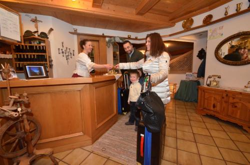 a woman standing in a store with a child at Hotel Albe in Rocca Pietore