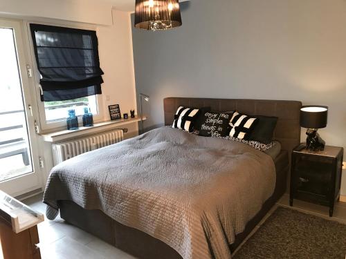 a bedroom with a bed with pillows and a window at Le Flair Appartement Mülheim in Mülheim an der Ruhr