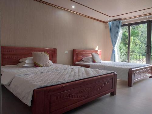 a bedroom with two beds and a window at Homestay Xuân Sơn 2 in Phú Thọ
