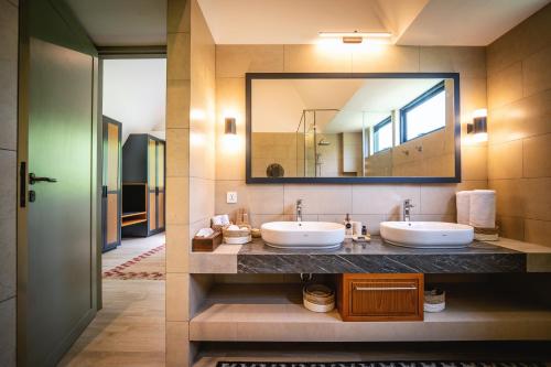 a bathroom with two sinks and a large mirror at Buyan Lakeside Villas in Bedugul