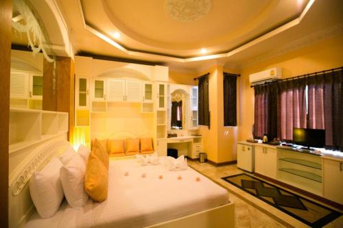 a bedroom with a large white bed in a room at Pharadhevi in Ban Dung