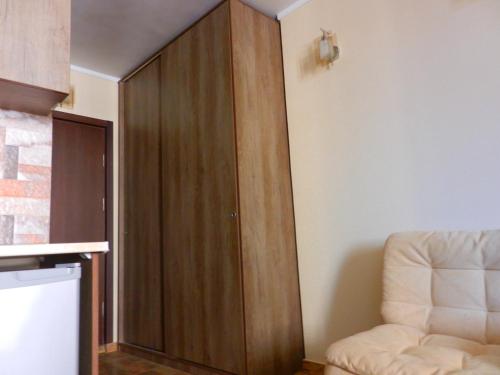 um grande armário de madeira num quarto com uma cadeira em Mimino Apartment Deluxe First Line (A I) em Batumi