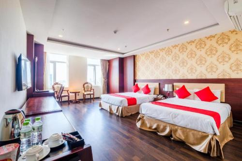 a hotel room with two beds with red pillows at GIC Land Hotel in Danang