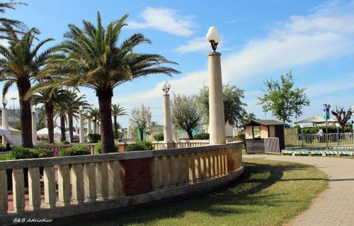 a park with palm trees and a fence at B&B Adriatico in Giulianova