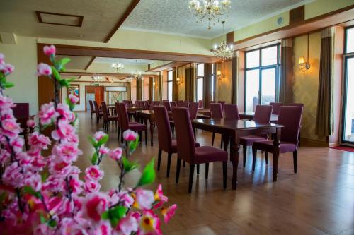 a dining room with tables and chairs and pink flowers at Atlas Hotel in Ulaanbaatar