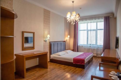 a bedroom with a bed and a table and a mirror at Atlas Hotel in Ulaanbaatar
