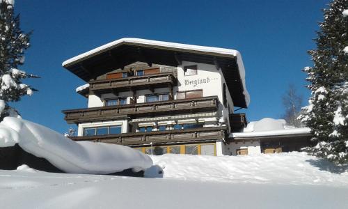 a large building with snow in front of it at Gästehaus Bergland in Berwang