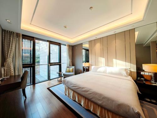 a bedroom with a large bed and a desk at Ascott Heng Shan Shanghai in Shanghai