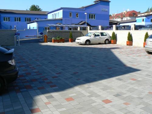 a car parked in a parking lot with blue buildings at Top Penzión Marína in Dolný Kubín