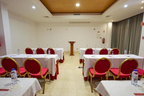 a conference room with white tables and red chairs at Grand Muthu Forte do Vale in Albufeira