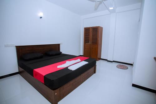 a bedroom with a large bed with a red blanket at LHK Dream Resort Matara in Palatuwa