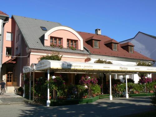 un bâtiment avec des fleurs et des plantes devant lui dans l'établissement Top Penzión Marína, à Dolný Kubín