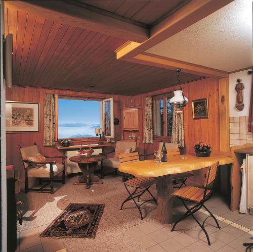 a living room with wooden walls and a table at Rigirolle in Rigi Kaltbad