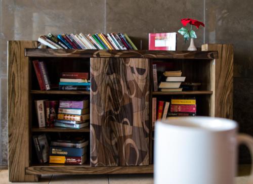 a book shelf filled with books next to a cup of coffee at Grand Muthu Forte do Vale in Albufeira