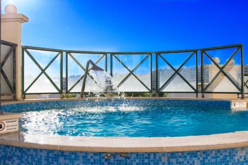 a swimming pool with a fountain in a building at Grand Muthu Forte do Vale in Albufeira