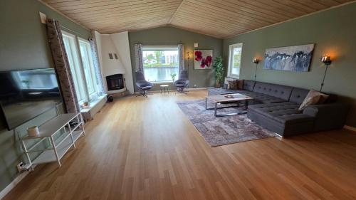 a living room with a couch and a tv at Prestelandet Guesthouse in Fredrikstad