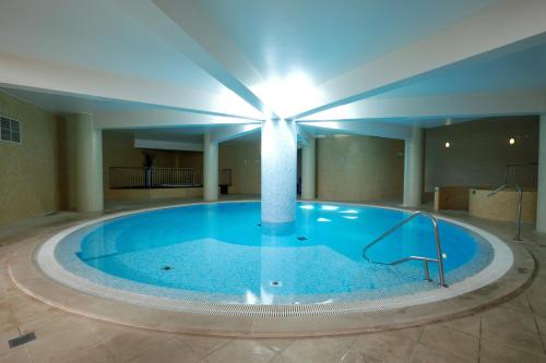a large swimming pool in a building with a light on the ceiling at Grand Muthu Forte do Vale in Albufeira