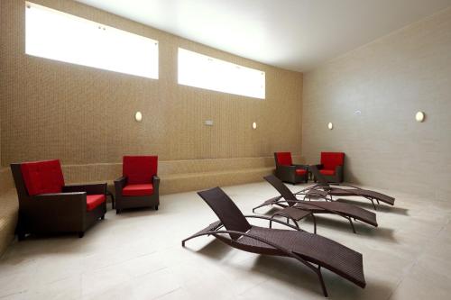 a waiting room with black chairs and red chairs at Grand Muthu Forte do Vale in Albufeira