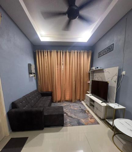 a living room with a couch and a ceiling fan at SYA Homestay Bachok in Bachok