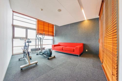 a living room with a red couch and a gym at Olympic Park I, Sun & Snow in Kołobrzeg