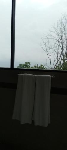 two white towels hanging in a bathroom window at Park Paradise in Galle