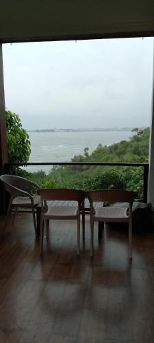 a table and benches on a balcony with a view of the ocean at Park Paradise in Galle