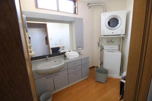 a bathroom with a sink and a large mirror at 郡上八幡 貸宿 GujoHachiman Kashiyado ICHI in Gujo