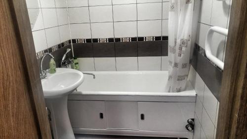 y baño con lavabo y bañera junto a un aseo. en Apartment on Pushkina 7, en Kobryn