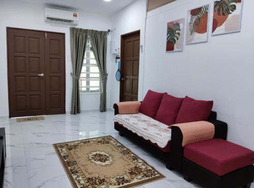 a living room with a red couch and a rug at SELAMA Merdeka Homestay 2-6pax in Selama