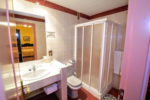 a bathroom with a toilet and a sink and a shower at Pension Rural La Fonda in Dúrcal