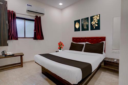 a bedroom with a large bed with a red headboard at Collection O IIM Mumbai Formerly Green View in Mumbai