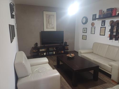 a living room with two white couches and a coffee table at SsaZza in Râmnicu Vâlcea