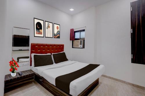 a bedroom with a large bed with a red headboard at Collection O IIM Mumbai Formerly Green View in Mumbai