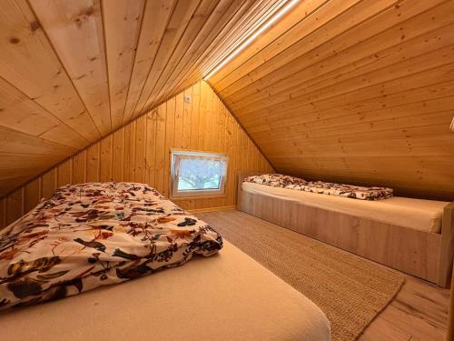 a bedroom with two beds in a wooden cabin at Zielone okiennice in Chobie