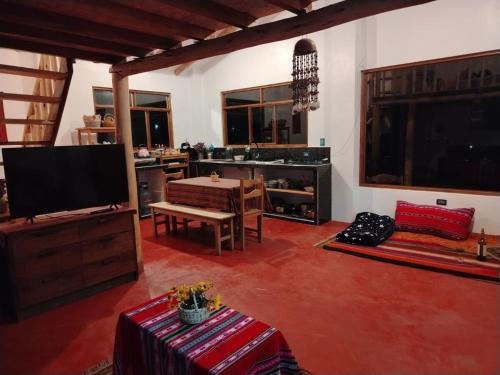 a living room with a flat screen tv and a table at Sami Huaypo Cabin in Cheqquerec
