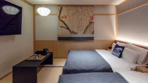 a bedroom with a bed and a table and a painting at Anook Resort & Spa Busan Haeundae in Busan