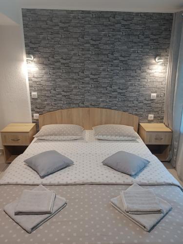 a large bed with two pillows on top of it at Rio rooms in Băile Herculane
