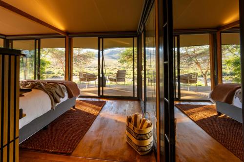 a bedroom in a glass house with a bed at Mount Ceder in De Straat