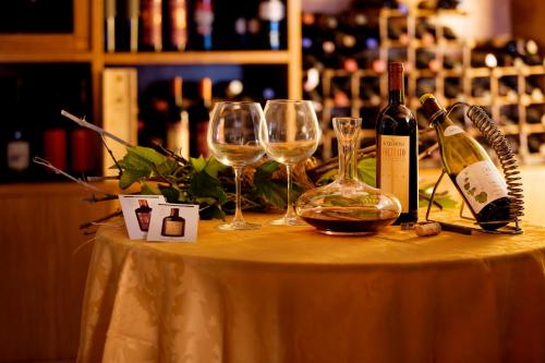 a table with two wine glasses and a bottle of wine at Hotel Corallo in Pomonte