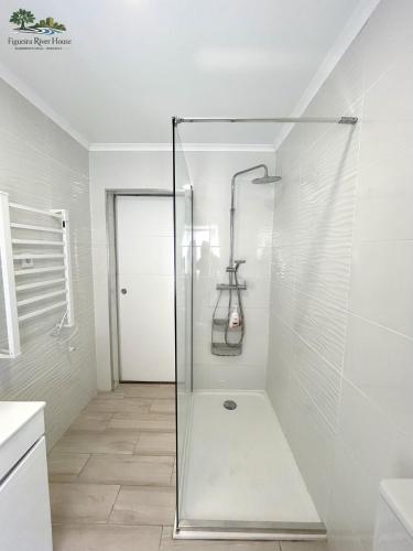 a shower with a glass door in a bathroom at Figueira River House in Bragança