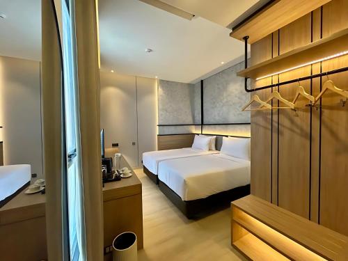 a hotel room with two beds and a desk and a room at Kaloka City Hotel Bima in Bima