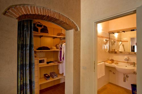 a bathroom with a sink and a toilet and a mirror at Hotel Corallo in Pomonte