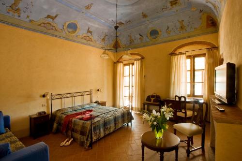 a bedroom with a bed and a table in a room at Hotel Corallo in Pomonte