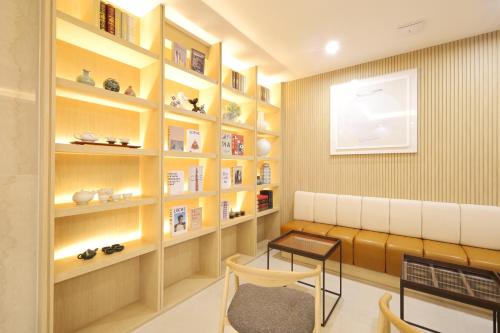 a living room with a bench and bookshelves at Nestly Hotel in Busan