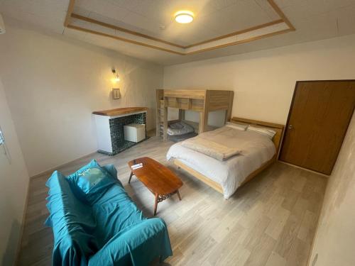 a bedroom with a bed and a couch at Old Sunny Garage in Tosashimizu