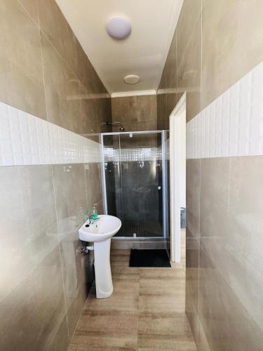 a bathroom with a sink and a shower at Gottys Lagoon Stay in Walvis Bay