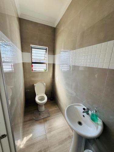 a bathroom with a toilet and a sink at Gottys Lagoon Stay in Walvis Bay