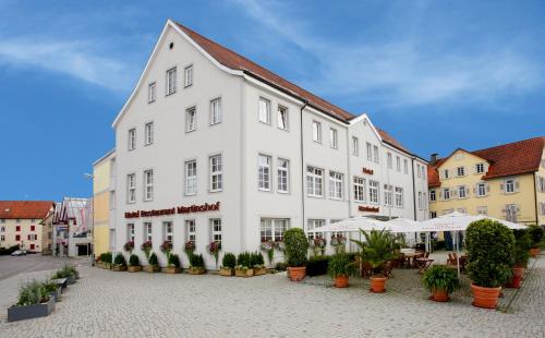 un grand bâtiment blanc avec des plantes devant lui dans l'établissement Martinshof, à Rottenburg